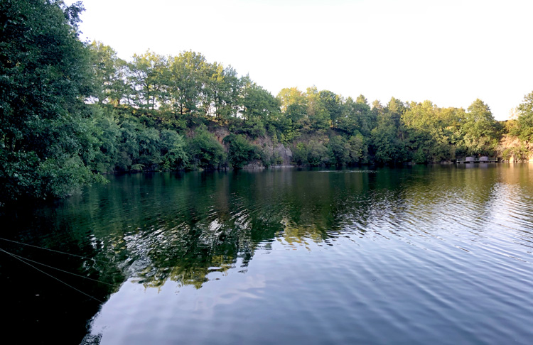 The sun lowers at shadows form at Quarry Bank Carp Fishery in France